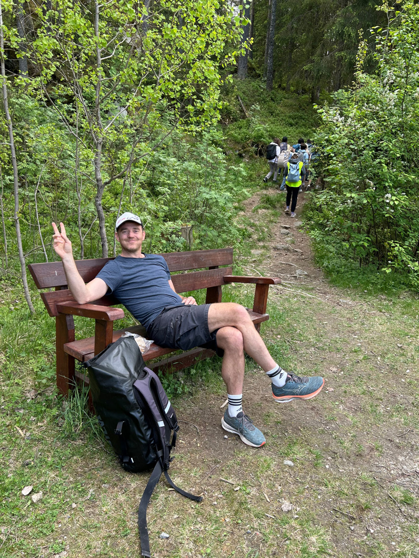 En person som sitter på en benk i skogen