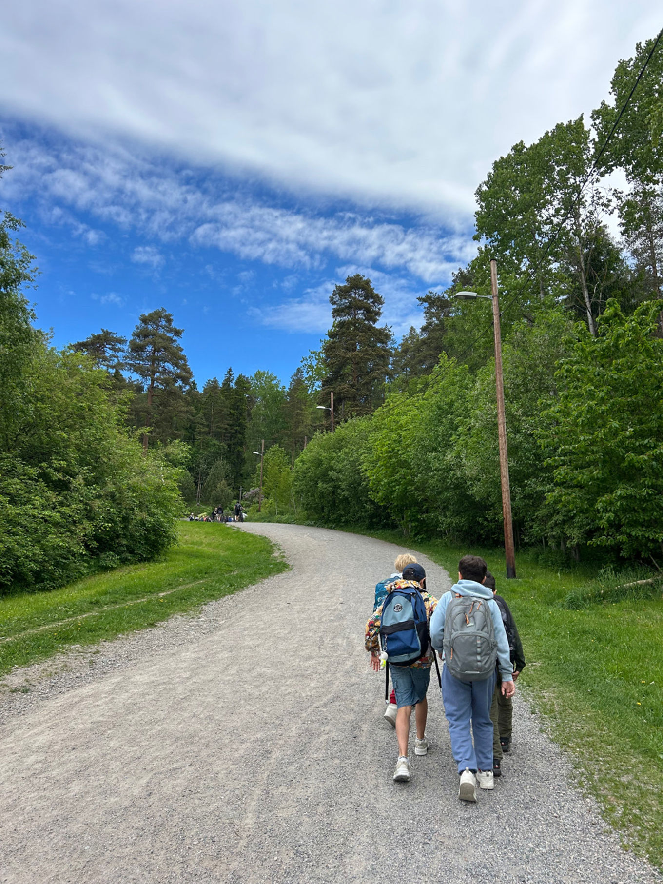 et par personer som går på en sti med trær og gress