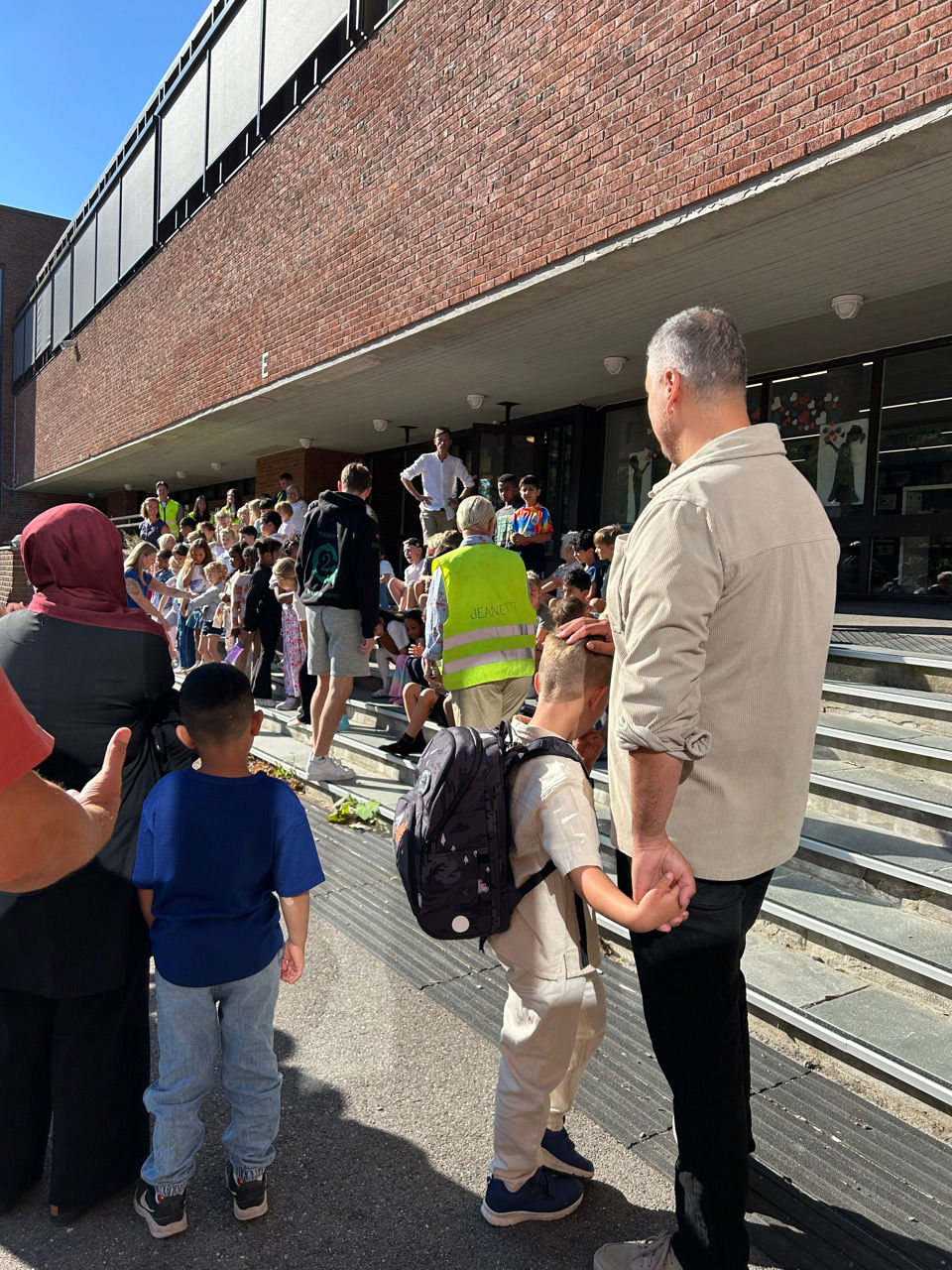 en gruppe mennesker som står utenfor en bygning