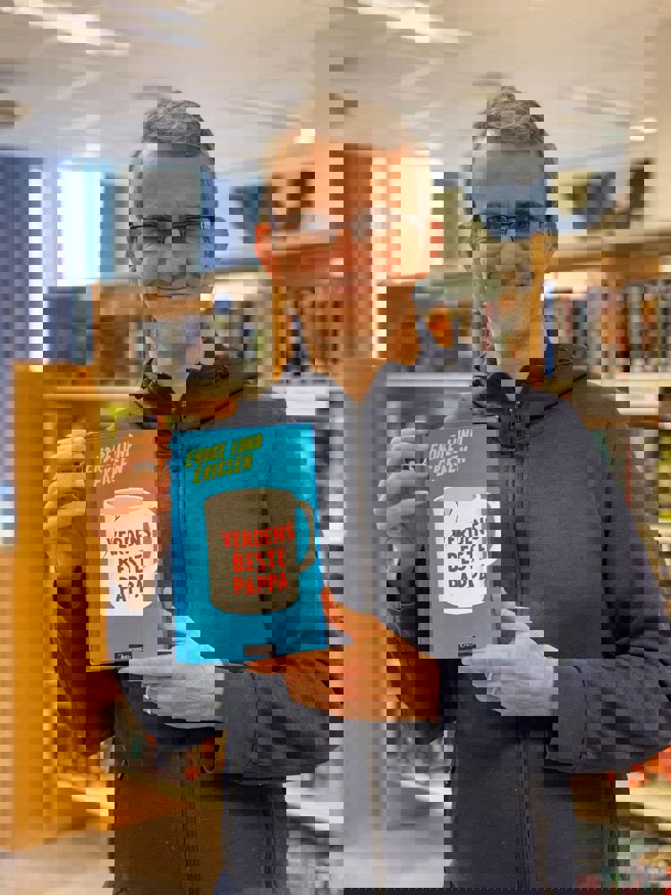 Forfatter Eriksen viser frem boken sin Verdens beste pappa