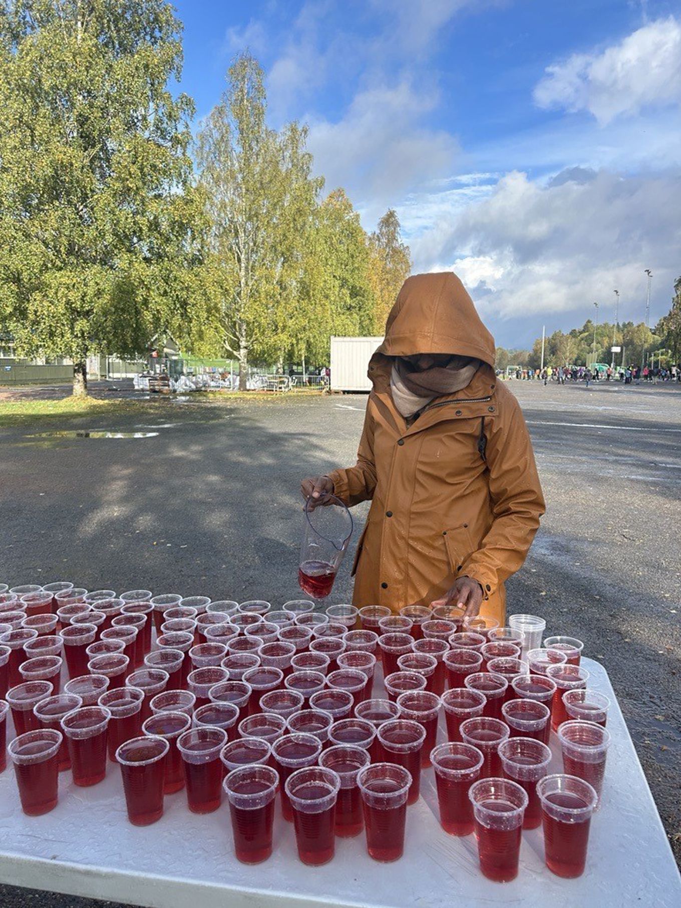 en person som har på seg en maske og holder et glass væske