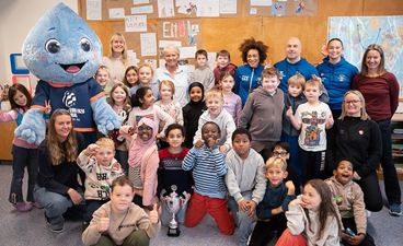 En gruppe mennesker som poserer for et bilde med en person i et plagg