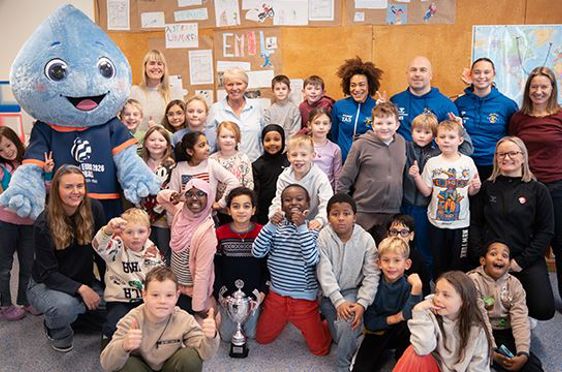 En gruppe mennesker som poserer for et bilde med en person i et plagg