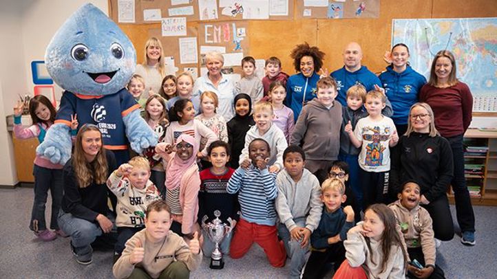 En gruppe mennesker som poserer for et bilde med en person i et plagg